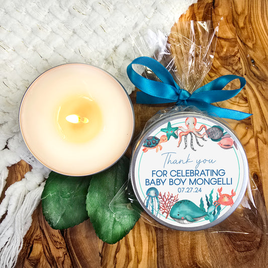 a candle and a tin of baby boy monobells on a wooden table