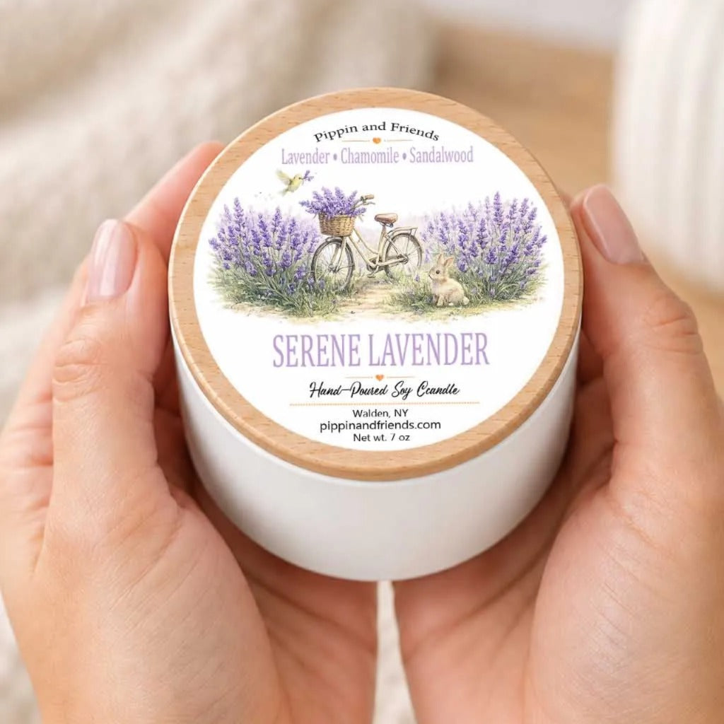 A person's hands holding a white container with a label that features an illustration of a bicycle surrounded by lavender flowers.