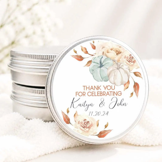A round tin lid with a floral design and text, placed on a white cloth.
