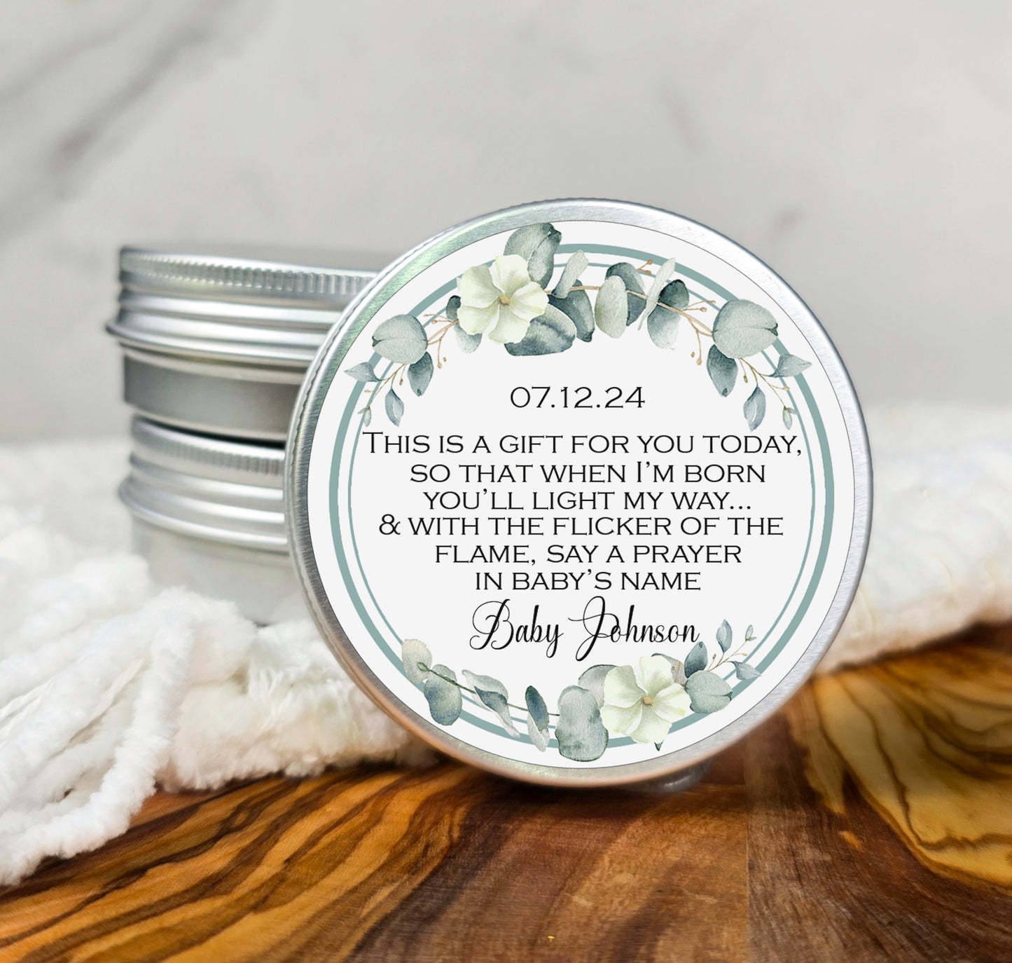 a small tin of personalized candles on a table