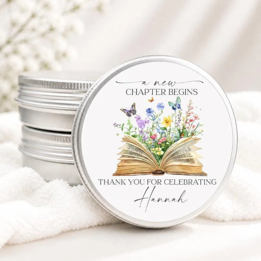 A round tin lid with a printed design on it, featuring an open book with flowers and butterflies.