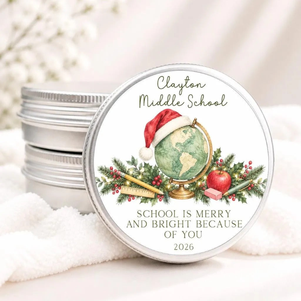 A round tin lid with a label featuring a globe, a Santa hat, and holiday decorations, along with the text "Clayton Middle School" and "School is Merry and Bright Because of You" and the year "2026".