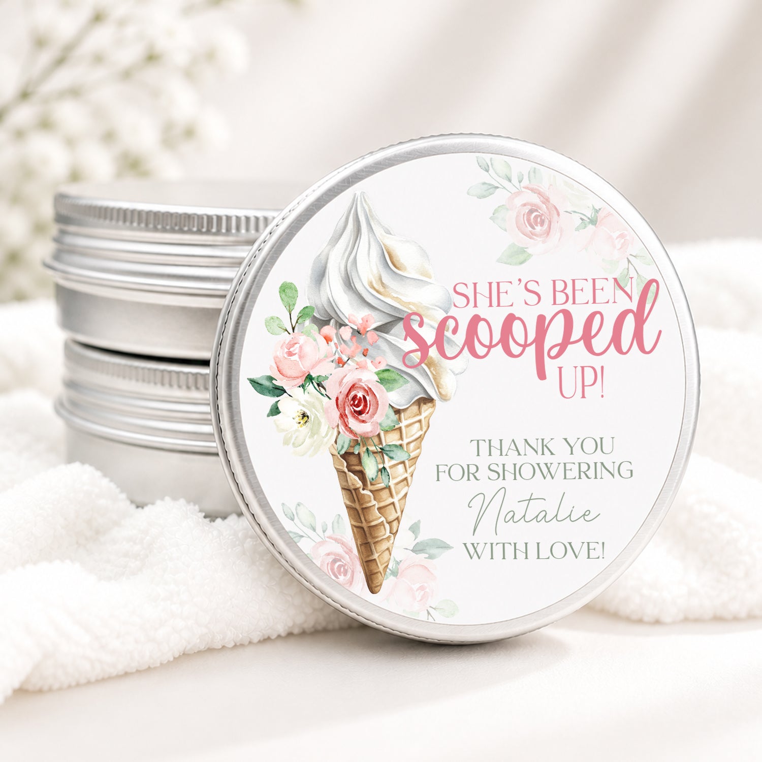 Personalized bridal shower candle favor in a silver tin featuring a watercolor ice cream cone decorated with soft pink flowers and the phrase "She's Been Scooped Up." Custom text thanks guests for showering the bride with love, making it a perfect favor for an ice cream-themed bridal shower.