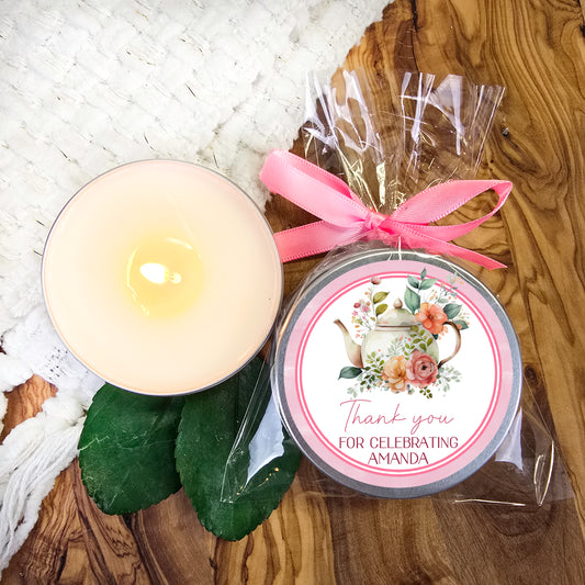 a white candle and a pink ribbon on a wooden table