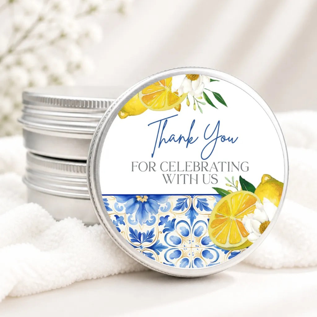 A round tin lid with a floral design and text on it, placed on a white cloth.