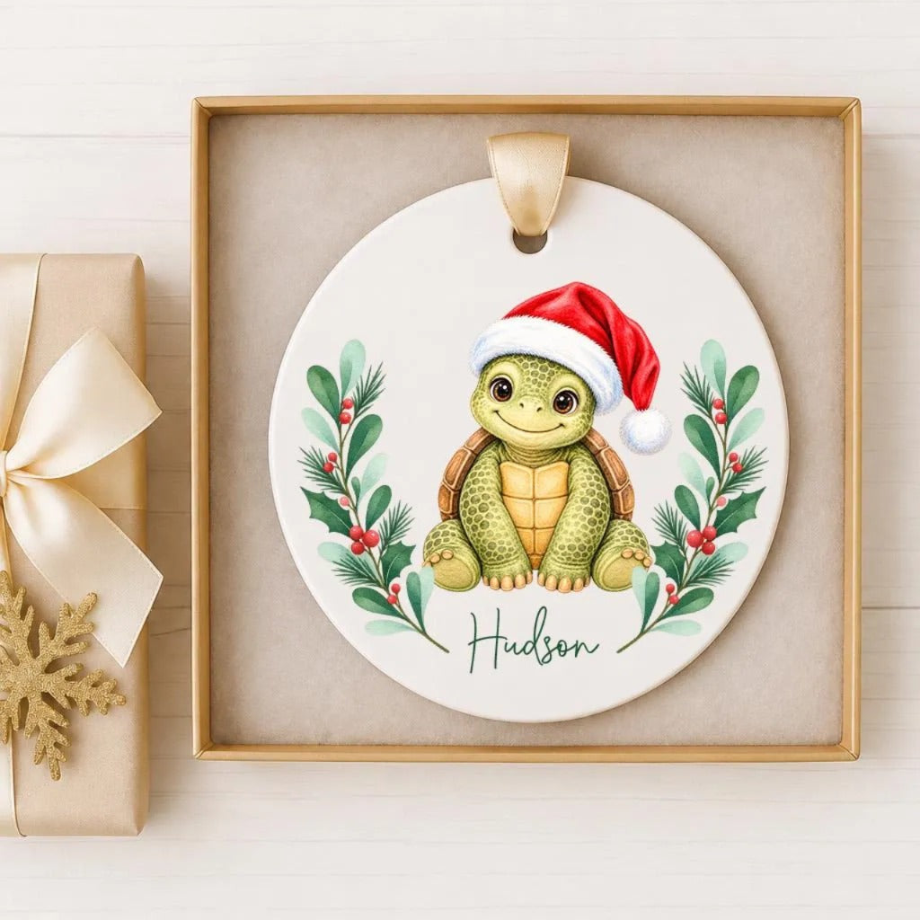 A ceramic ornament featuring a smiling turtle wearing a Santa hat, surrounded by holiday decorations such as pine branches and berries.