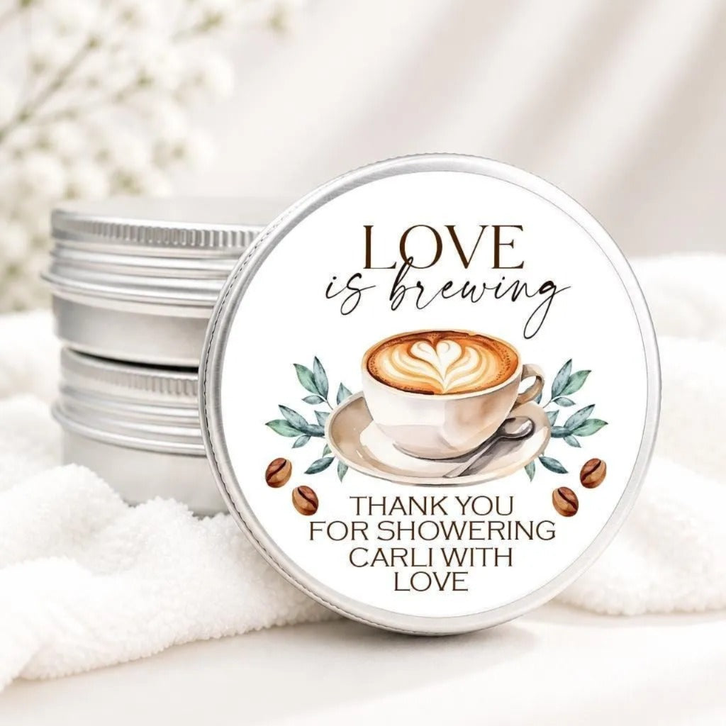 A round tin lid with a coffee cup illustration and text, placed on a white cloth.