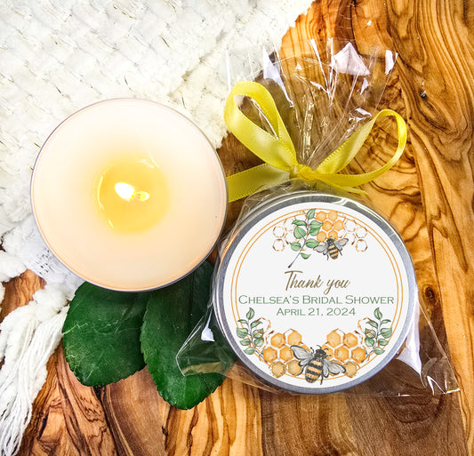 a candle and a jar of personalized candles on a wooden table