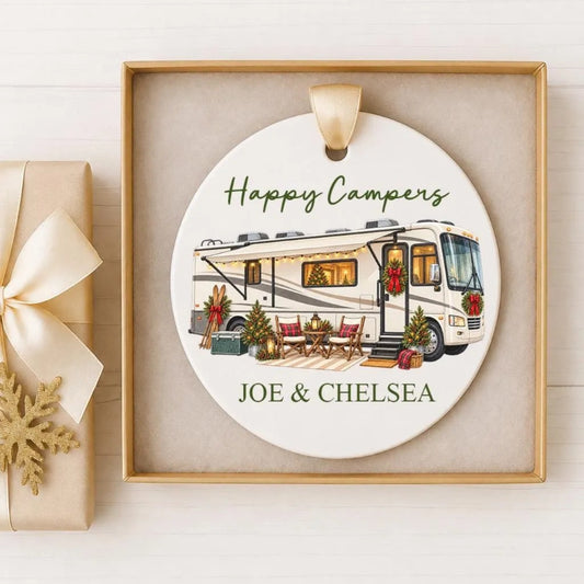 A white ceramic ornament with a picture of a recreational vehicle and holiday decorations, along with the text "Happy Campers" and "Joe & Chelsea".
