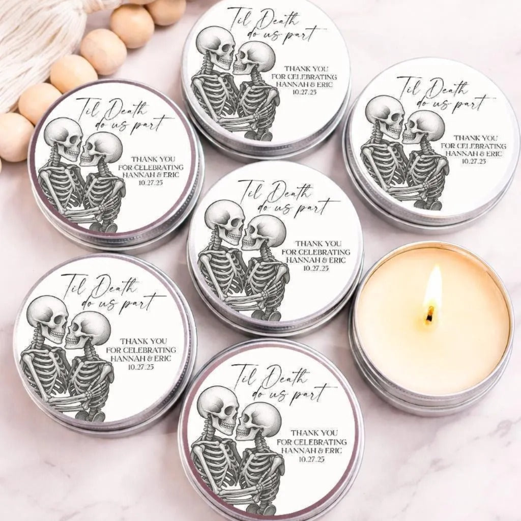 a collection of round candles with labels that read "Til Death do us part" and "Thank you for celebrating Hannah & Eric 10.27.25". The candles are arranged on a marble surface, with some candles lit and others unlit.