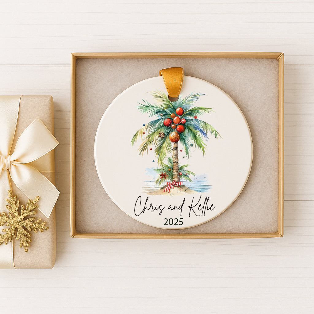 A white ceramic ornament with a palm tree design and red ornaments, placed in a gold box.