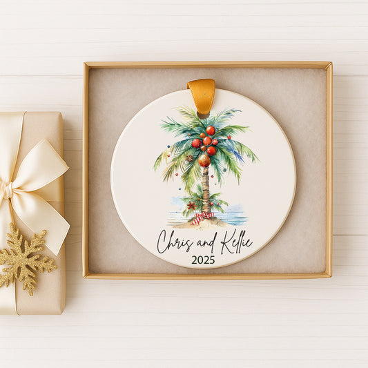 A white ceramic ornament with a palm tree design and red ornaments, placed in a gold box.