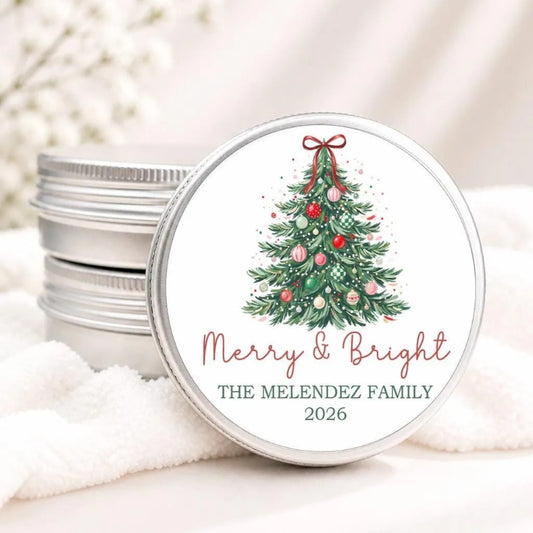 A round tin lid with a Christmas tree design and the text "Merry & Bright" and "THE MELENDZ FAMILY 2026" printed on it.