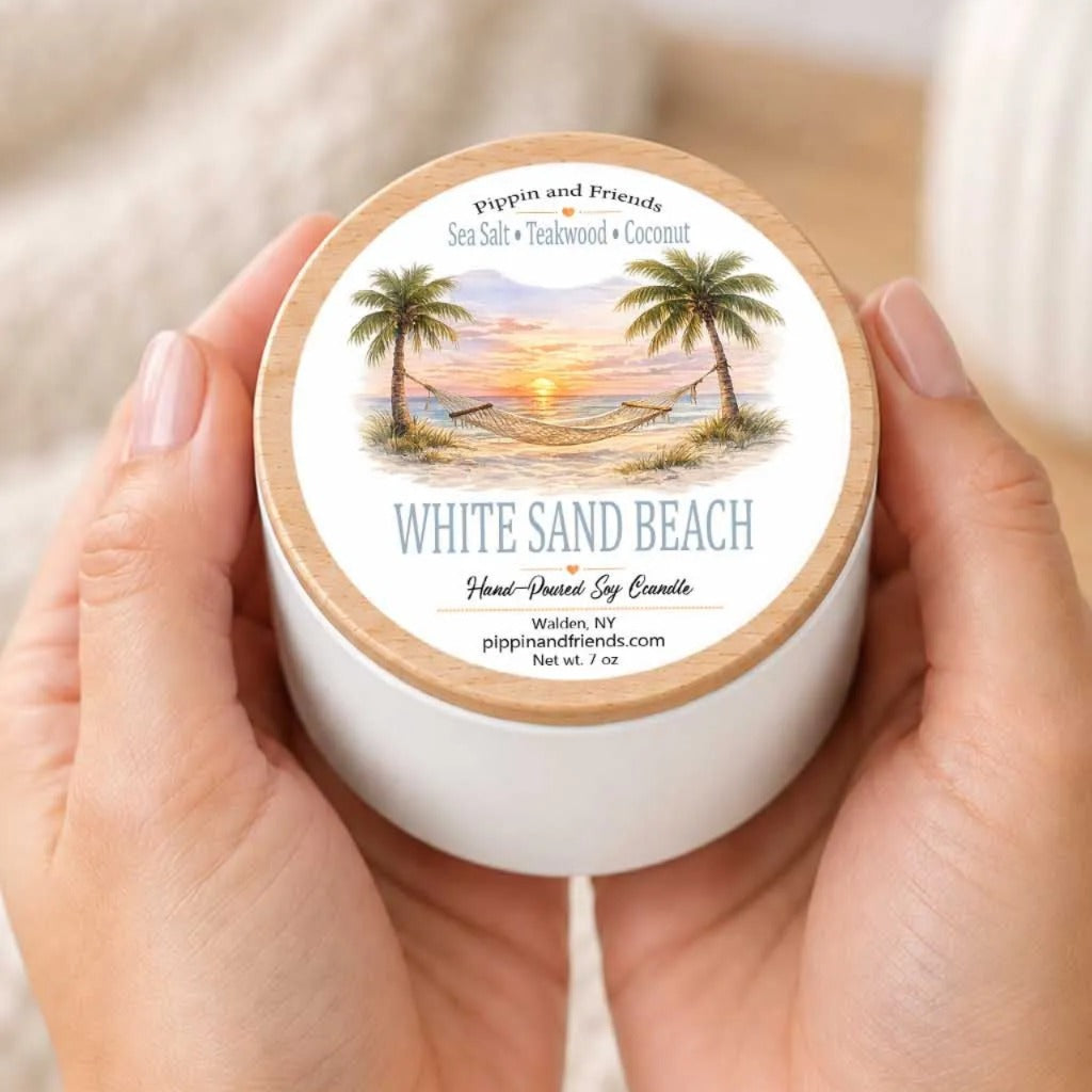 A person's hands holding a white container with a label that features a tropical beach scene with palm trees and a sunset.