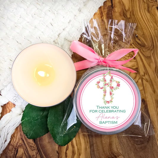 a candle with a pink ribbon on a table