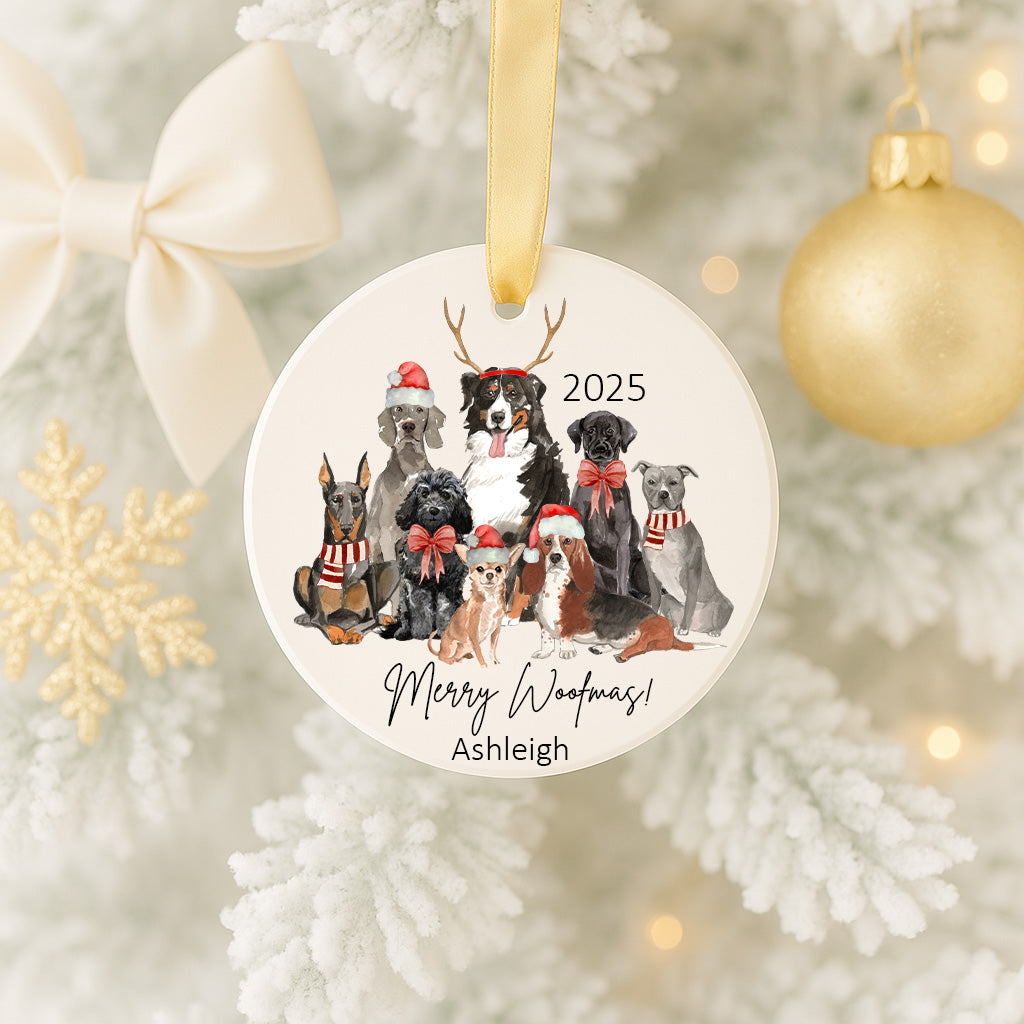 A white Christmas tree ornament featuring a group of dogs wearing Santa hats and scarves, with the text "Merry Woofmas!" and "Ashleigh" written on it.