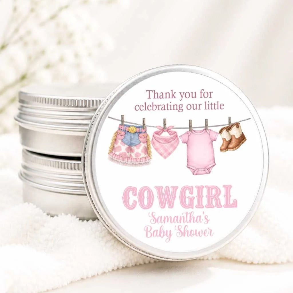 A round tin with a label that says "Thank you for celebrating our little COWGIRL Samantha's Baby Shower" and features illustrations of baby clothes and shoes hanging on a clothesline.