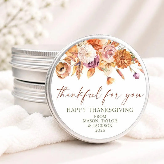 A round tin lid with a floral design and text on it, placed on a white cloth.