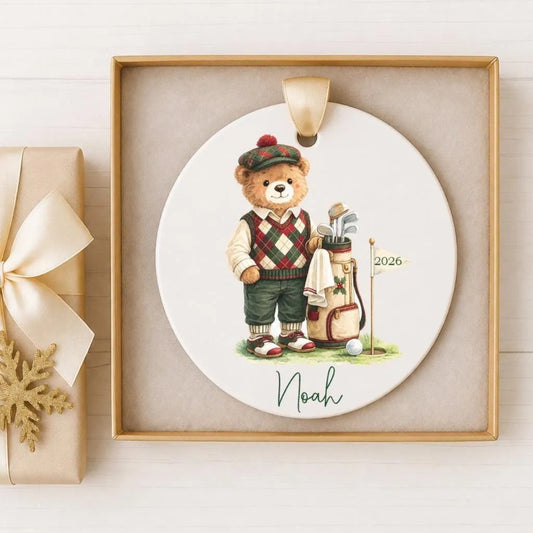 A ceramic ornament featuring a teddy bear wearing a golf outfit and holding a golf club, with the name "Noah" written below the image.