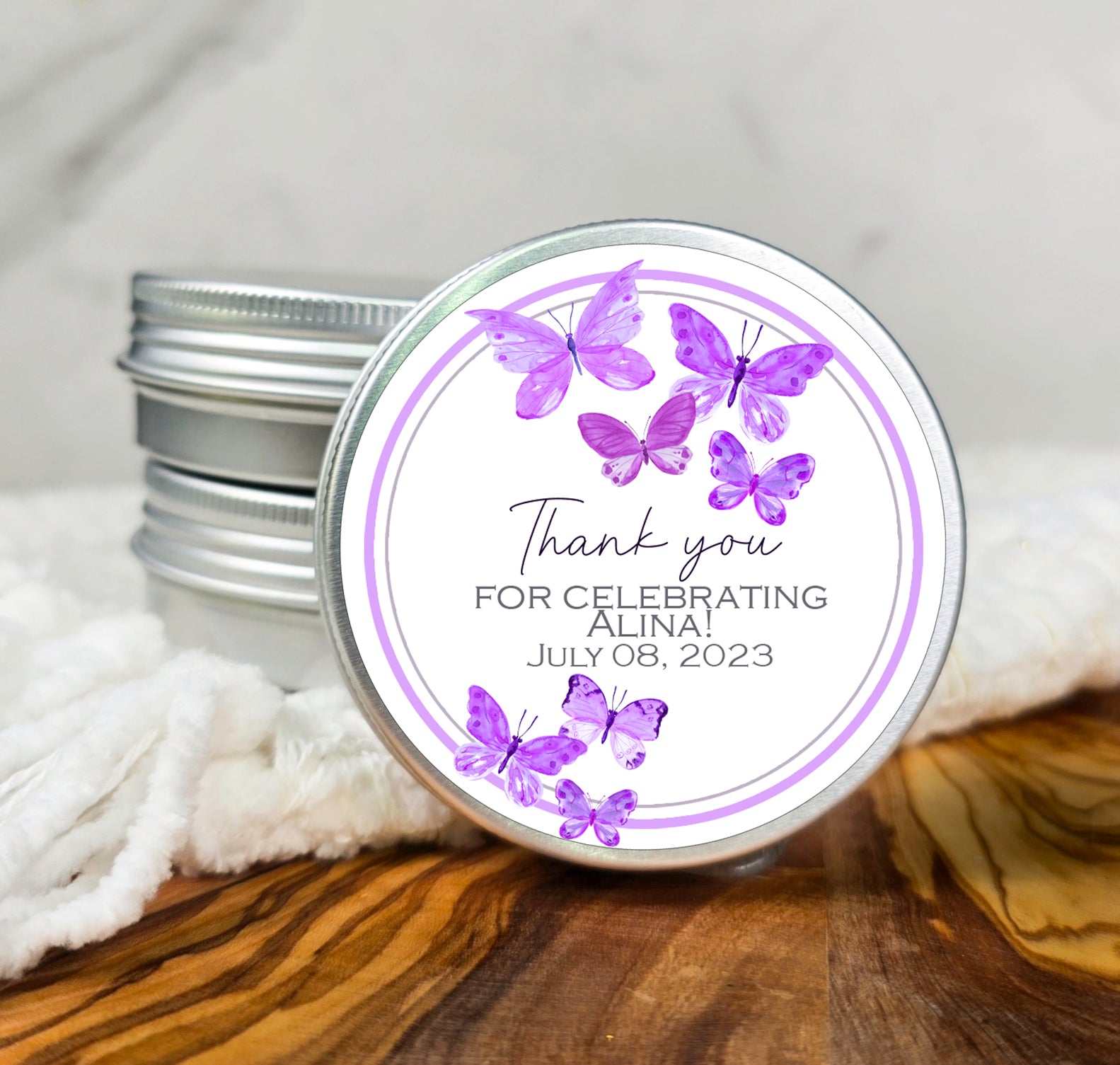 a jar of personalized wedding favors with purple butterflies