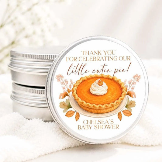 A round tin lid with a label that says "Thank you for celebrating our little cute pie! Chelsea's Baby shower" and features an illustration of a pumpkin pie.