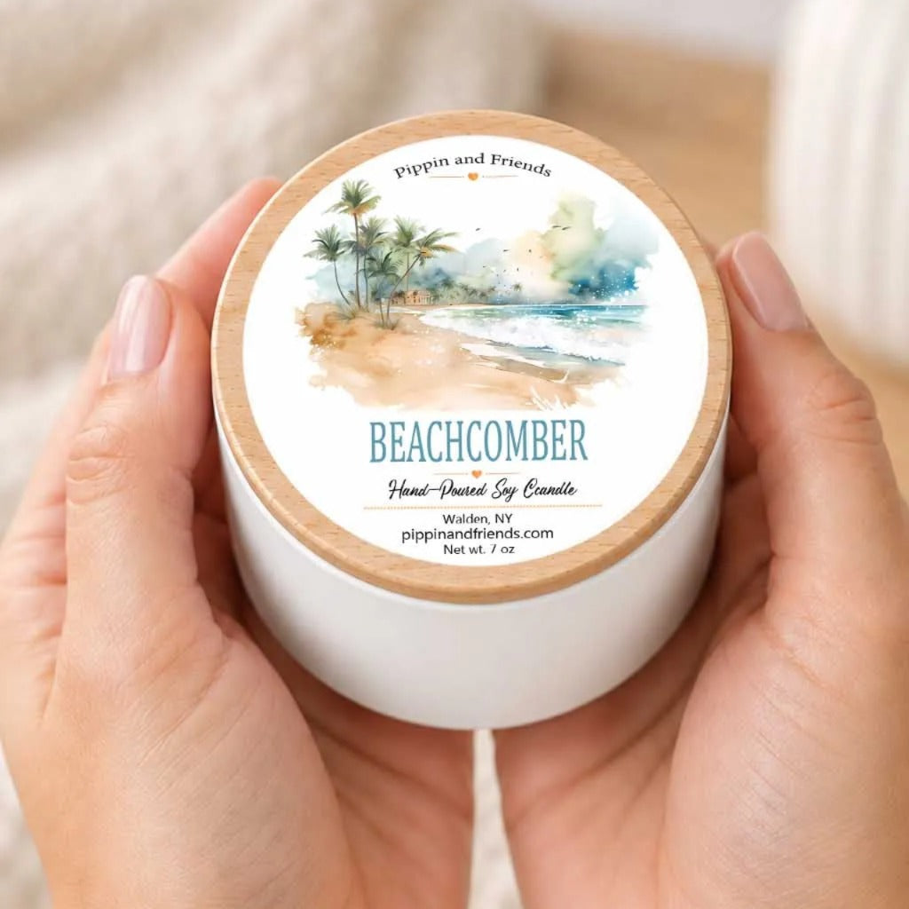 A person's hands holding a white container with a label that features a beach scene.