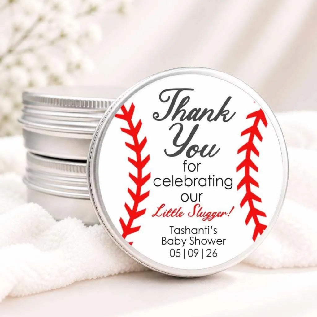 A round tin lid with a label that says "Thank You for celebrating our Little Slugger! Tanishi's Baby Shower 05/09/26"