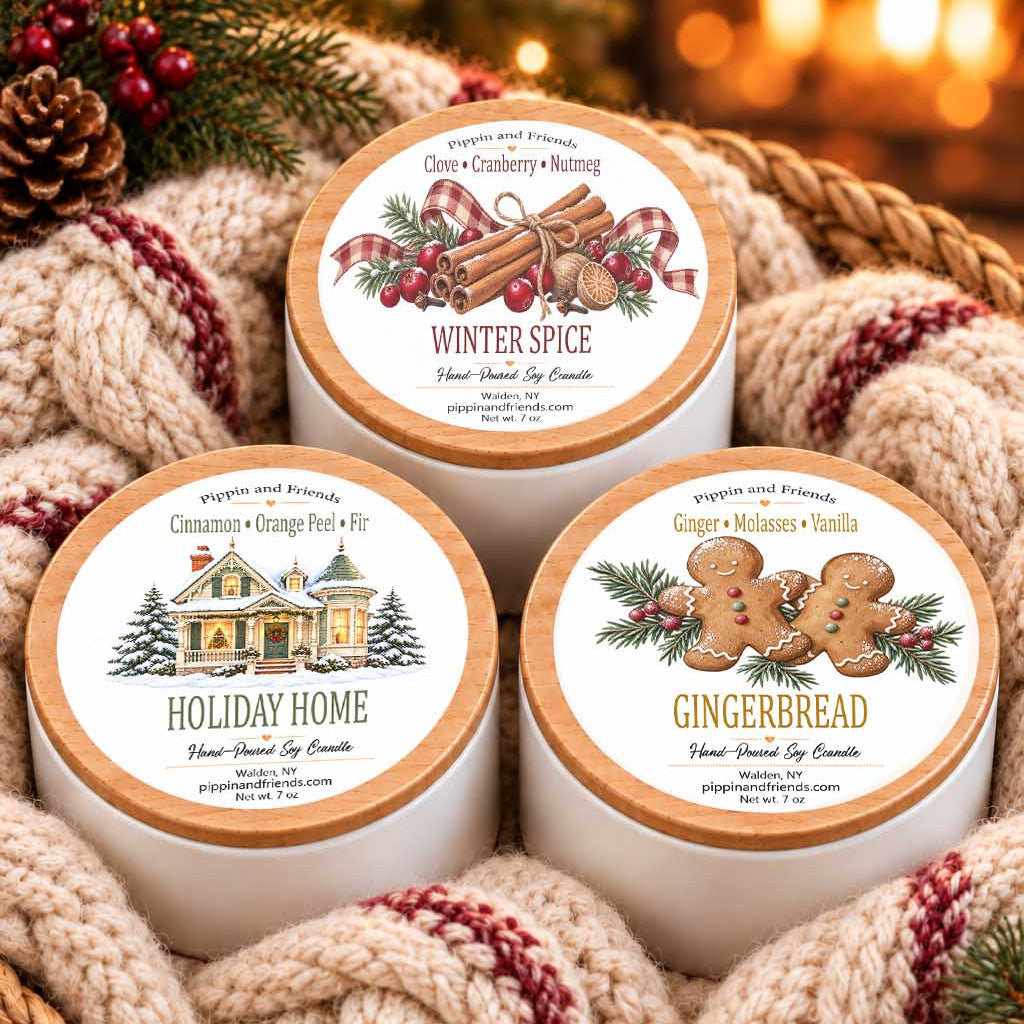 Holiday candle gift set featuring three 7 oz soy candles in white tins with wood-look lids: Winter Spice, Holiday Home, and Gingerbread.