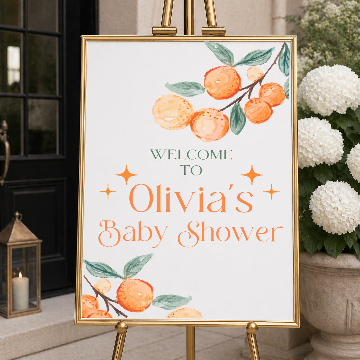 Personalized A Little Cutie baby shower welcome sign with citrus design displayed on easel at event entrance.