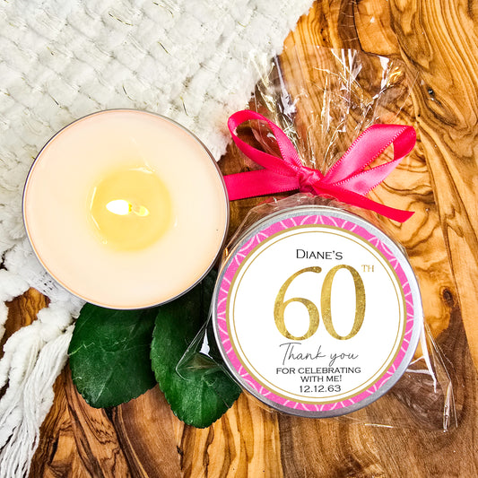 a candle with a pink ribbon next to it