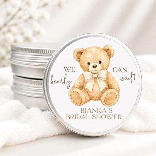 A round tin lid with a teddy bear illustration and text, placed on a white cloth.