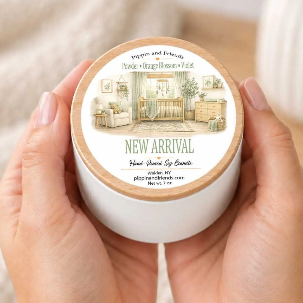 A person's hands holding a white container with a label that features an illustration of a nursery room.