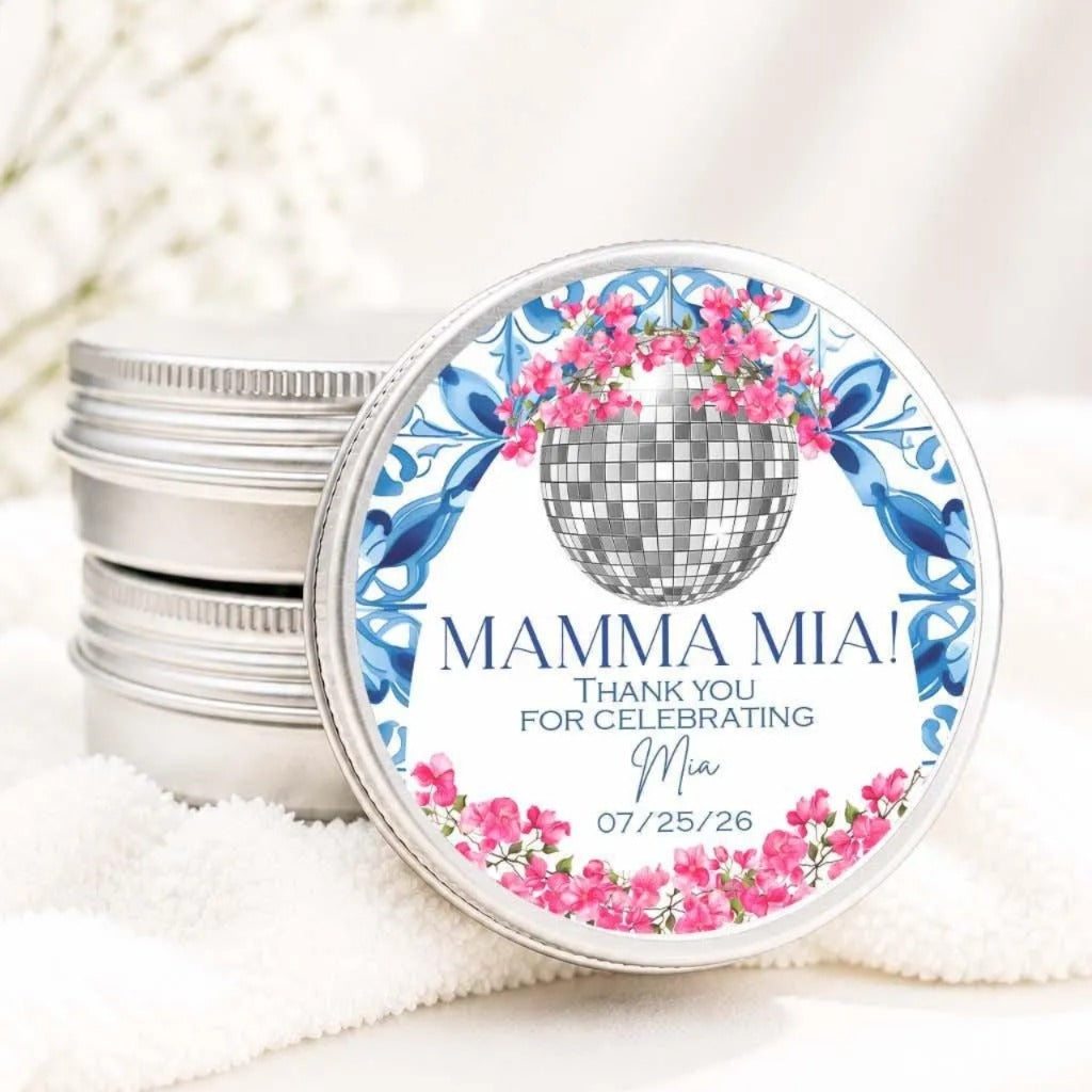 A round tin lid with a decorative design featuring a disco ball and pink flowers, along with the text "MAMMA MIA! Thank you for celebrating Mia 07/25/26".