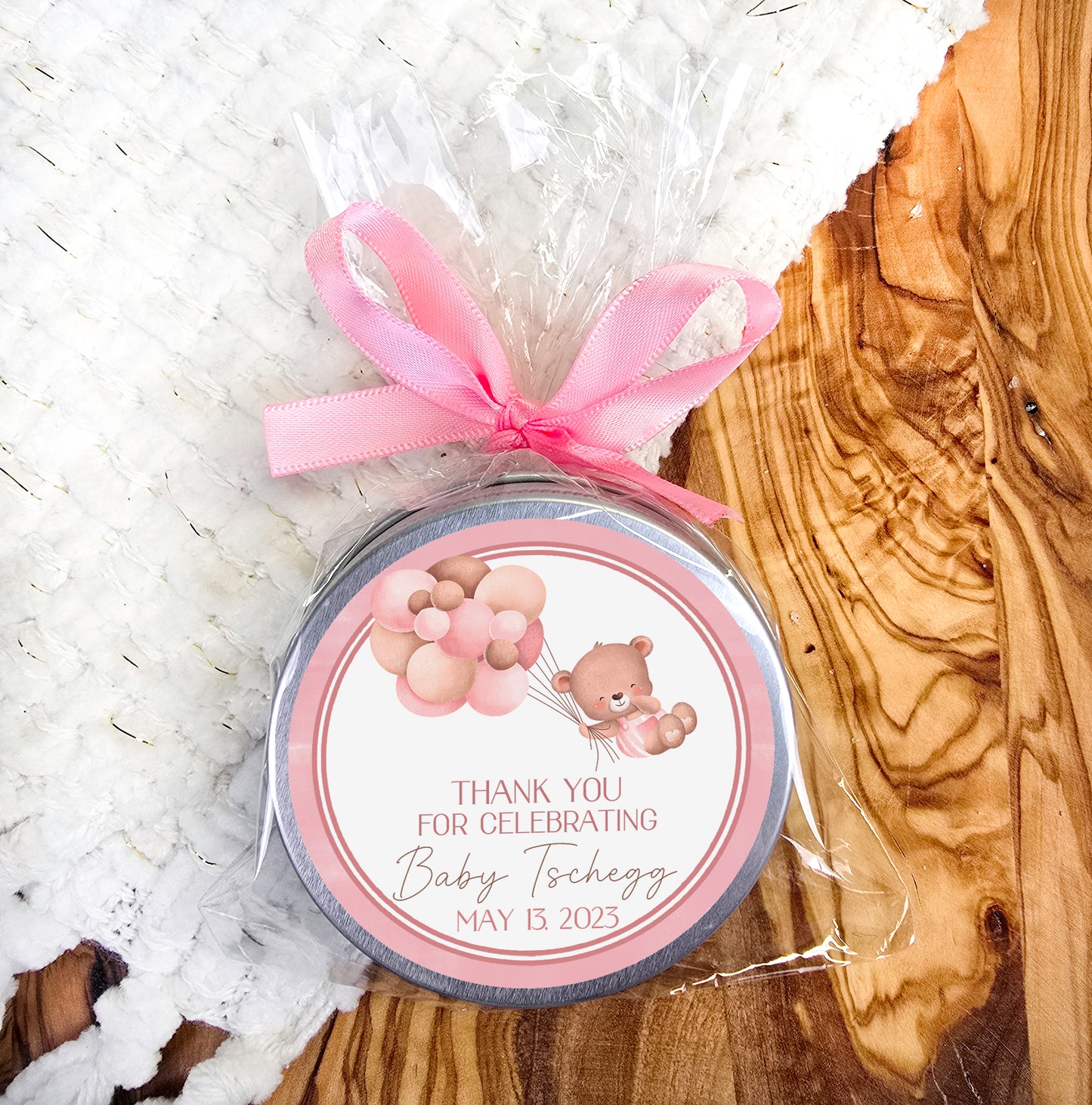 a small jar with a pink ribbon on it