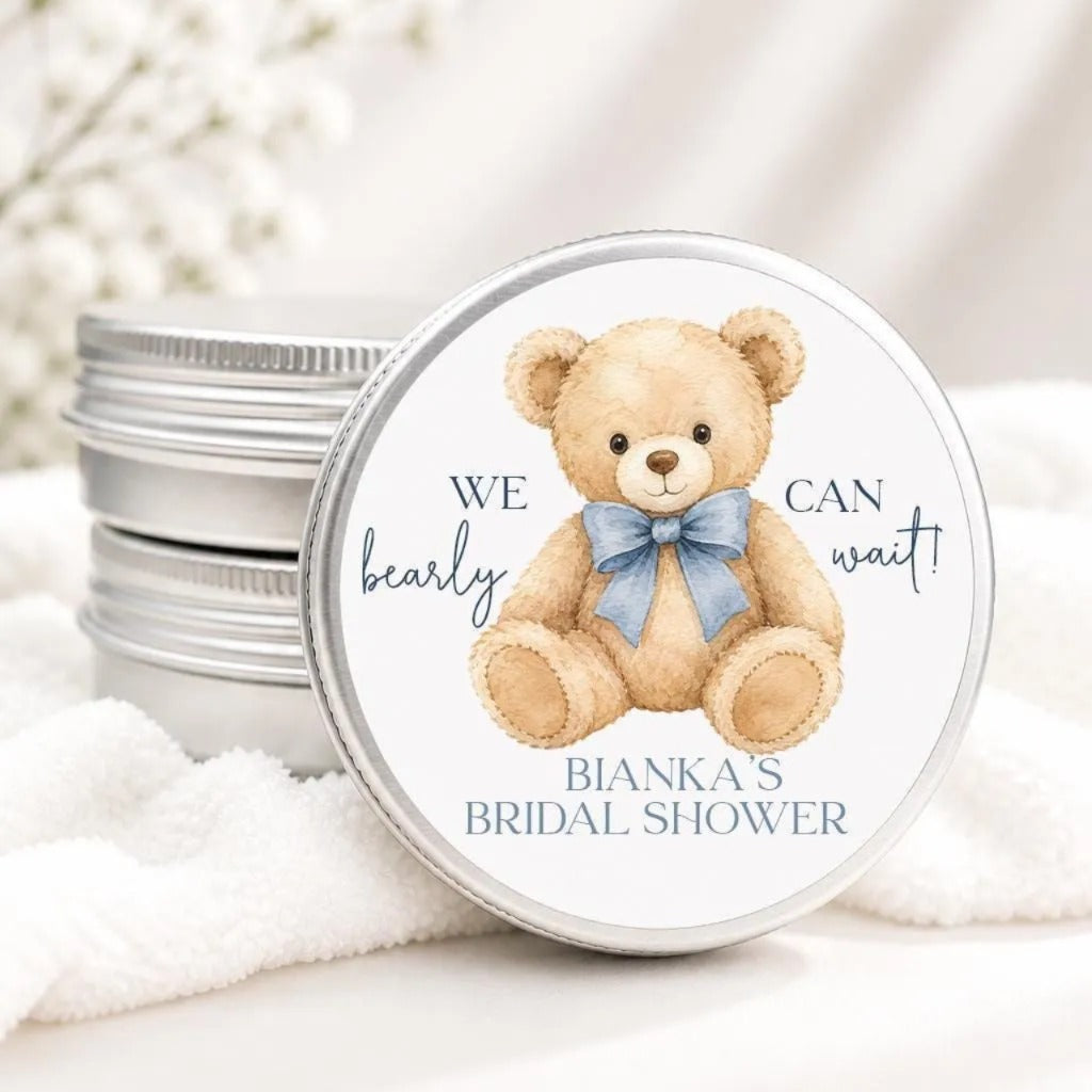 A round tin lid with a teddy bear illustration and text, placed on a white cloth.