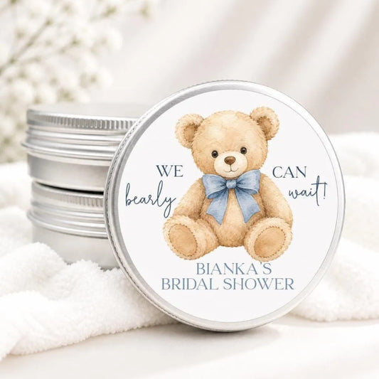 A round tin lid with a teddy bear illustration and text, placed on a white cloth.