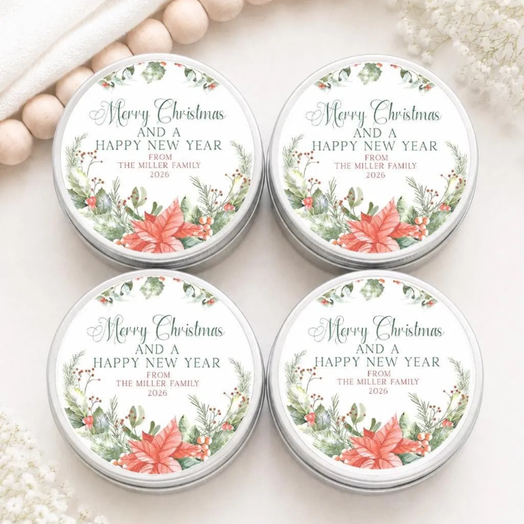 four tin containers with holiday-themed labels, arranged on a white surface.