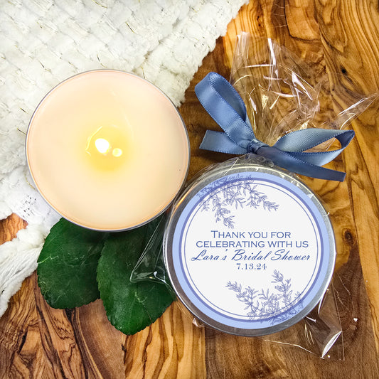 a white candle and a blue ribbon on a wooden table