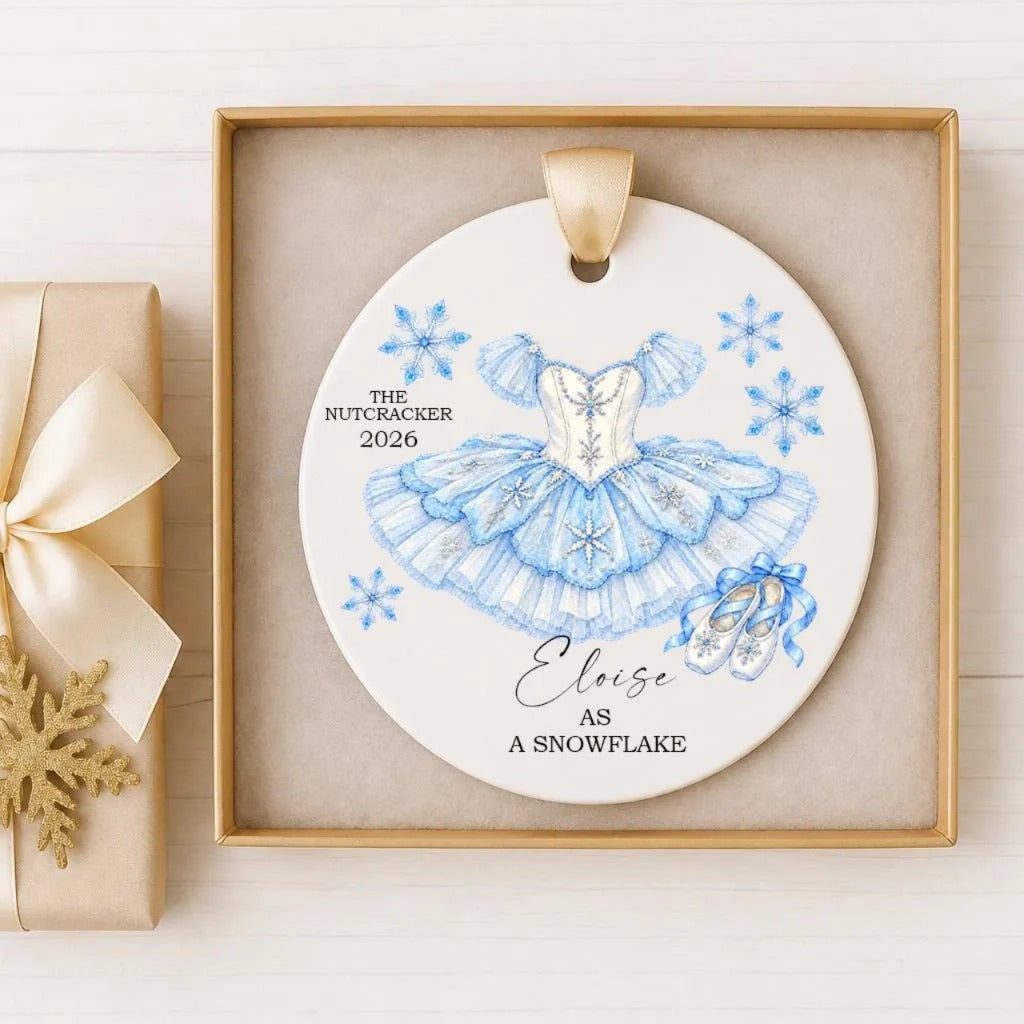 A decorative ornament featuring a blue ballerina dress and snowflakes, with the text "The Nutcracker 2020" and "Elise as a Snowflake" printed on it.