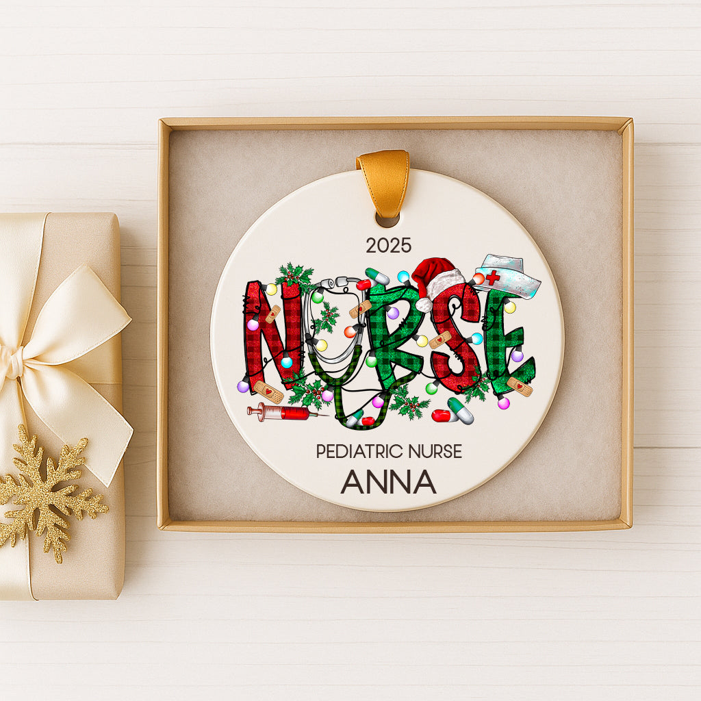 A white ornament with the word "NURSE" written on it, surrounded by Christmas-themed decorations such as lights, ornaments, and a snowflake. The ornament is displayed in a gold box, and there is a gift box with a gold ribbon next to it.