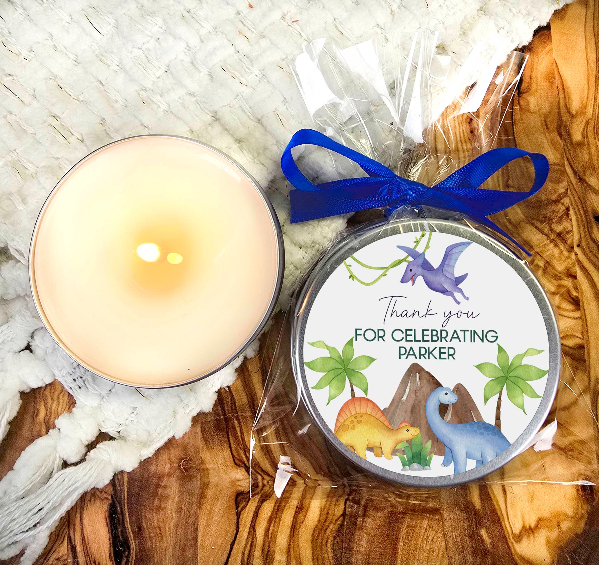 a candle and a tin with a blue ribbon