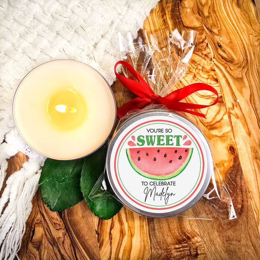 a candle and a tin of wax sitting on a table