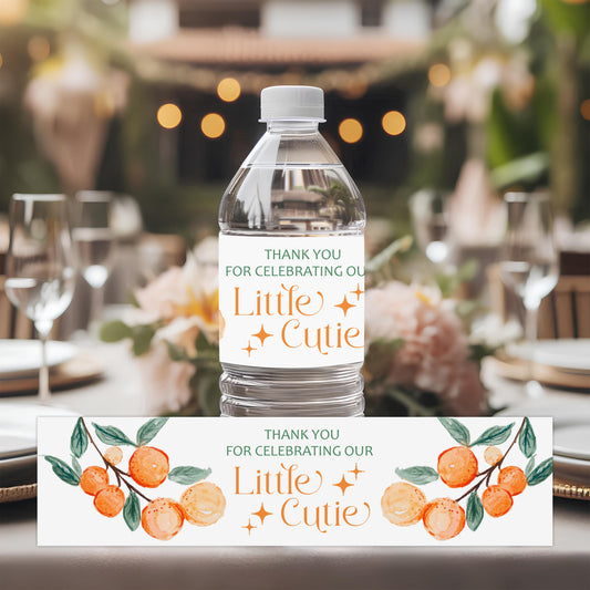 A Little Cutie baby shower water bottle labels with orange citrus design applied to bottles for drink station decor.