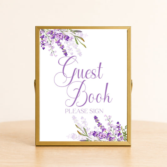 Lavender guest book sign with purple floral design displayed on table for bridal shower or wedding sign-in decor.