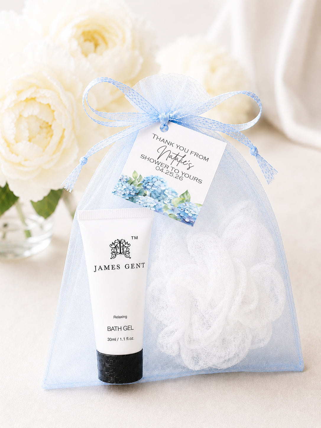 Personalized hydrangea baby shower spa favor kit with bath and body essentials in a soft blue organza gift bag