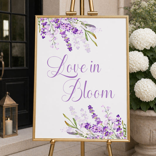 Lavender love in bloom welcome sign with purple floral design displayed on easel for bridal shower or wedding entrance decor.