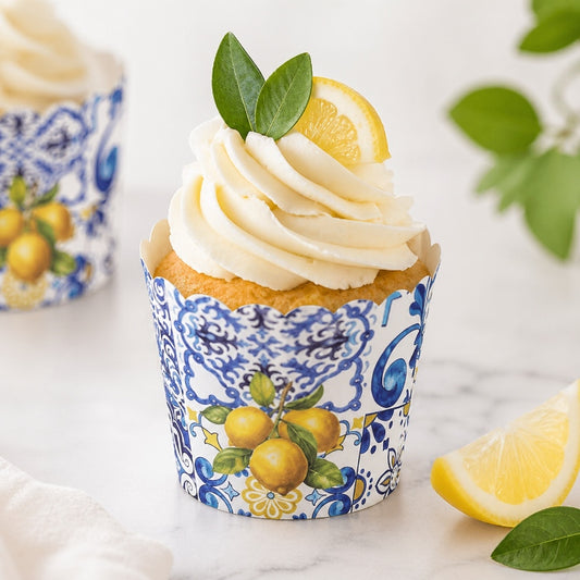 Mediterranean lemon cupcake liner with blue tile design holding frosted cupcake topped with lemon slice and greenery.