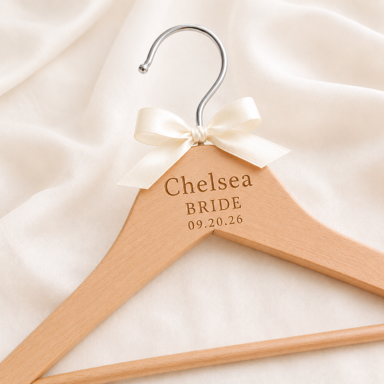 Personalized wooden bridal hanger engraved with bride's name, wedding title, and date, featuring a satin bow and silver hook for wedding dress display.