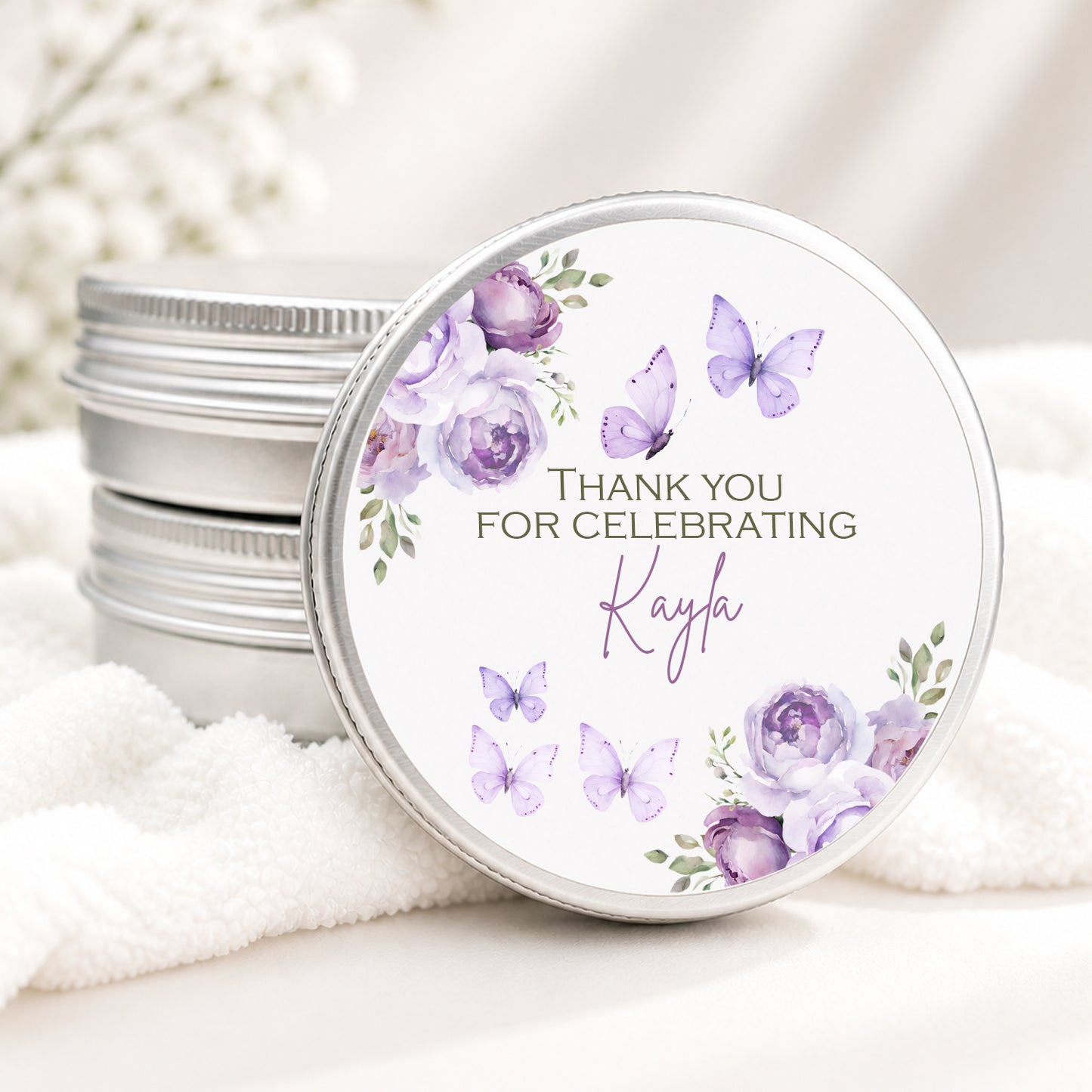 Personalized butterfly candle favor in a silver tin featuring lavender watercolor flowers, purple butterflies, and custom event details, displayed on a soft white background.