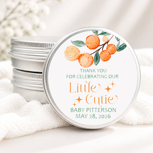 Personalized Little Cutie baby shower candle favor in a silver tin featuring watercolor oranges, greenery, and custom baby shower details, displayed on a soft white background.